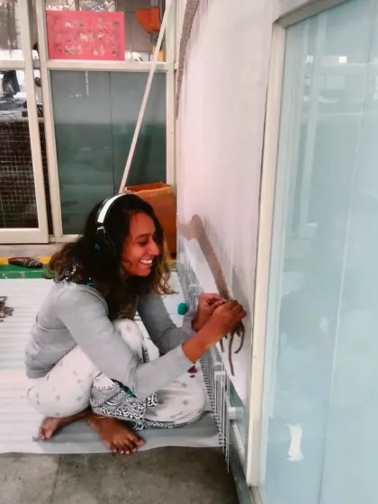 Me getting hands-on with the tapestry project, completely absorbed in the new challenge.