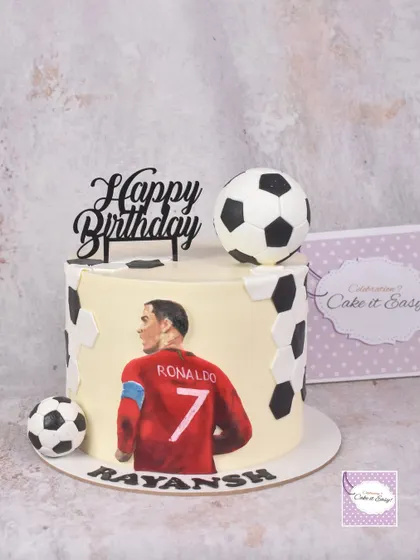 For a young football fan, we created this dessert table centered around a hand-painted Ronaldo cake. The main cake is decorated with buttercream and features a detailed, edible painting.