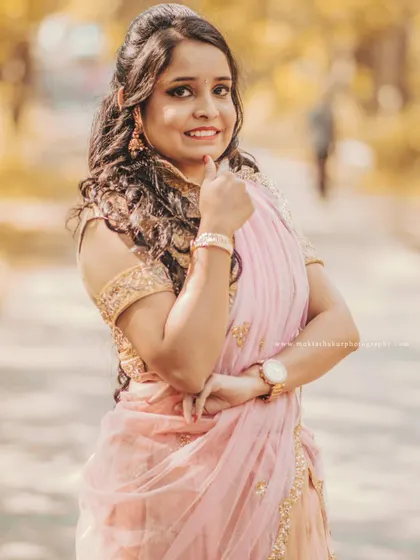 A beautiful solo portrait of the bride-to-be during her pre-wedding shoot, looking radiant in a lovely pink and gold lehenga.