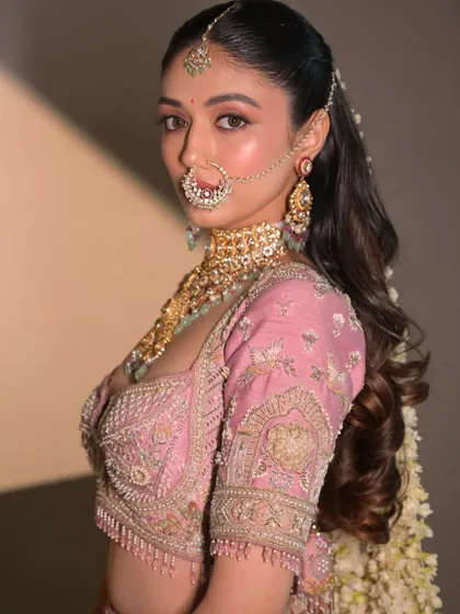 A confident and chic pose. The makeup is modern and sophisticated, perfect for a fashion-forward bride.