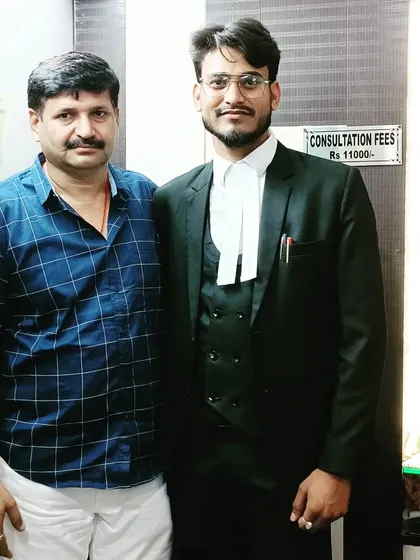 With a client or senior colleague in my office. The sign "Consultation Fees" is visible, indicating a professional setting.