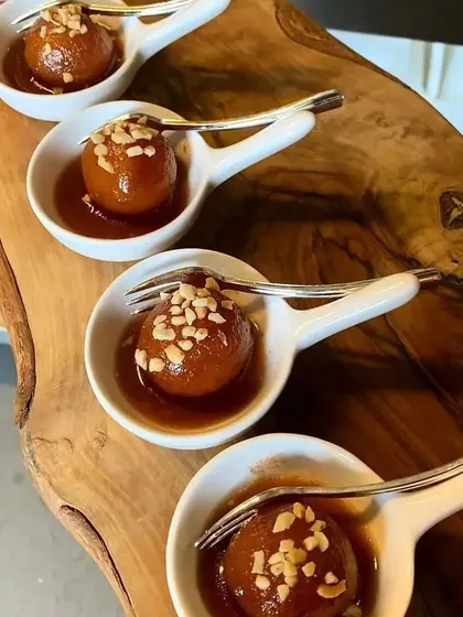 Our Gulab Jamuns are soft, syrupy, and incredibly delicious. We serve them in elegant, individual portions, garnished with chopped nuts for an added crunch.