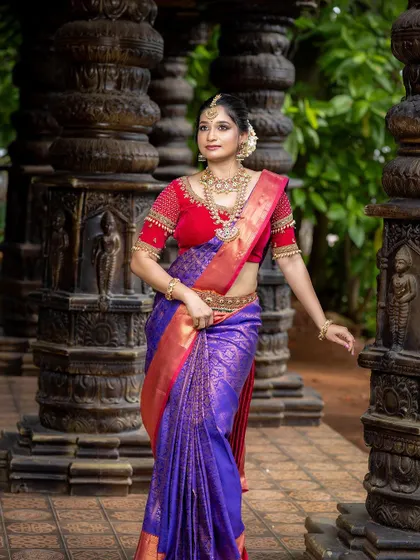 A full view of the bride against a temple-like backdrop, emphasizing the traditional theme.