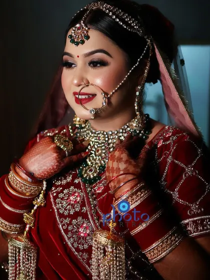 A radiant bridal portrait capturing the bride's smile and the stunning details of her red lehenga, chooda, and heavy jewelry.