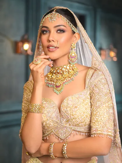 A beautiful portrait of the bride in her ivory lehenga. The makeup is soft and romantic, with a focus on glowing skin and a gentle smokey eye.