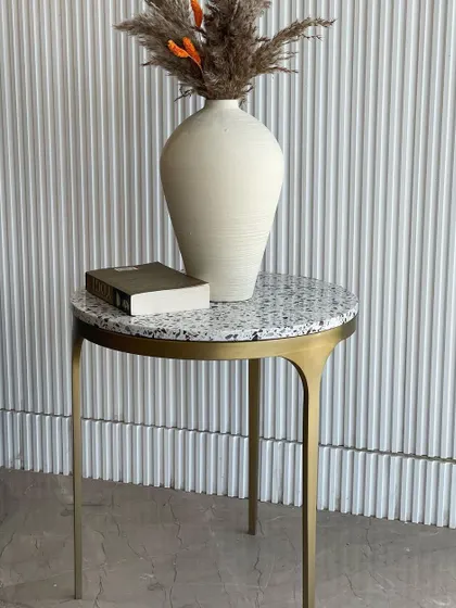 The 'Tyra' side table styled with a vase and book. Its simple, elegant design makes it a versatile piece for any corner of your home.