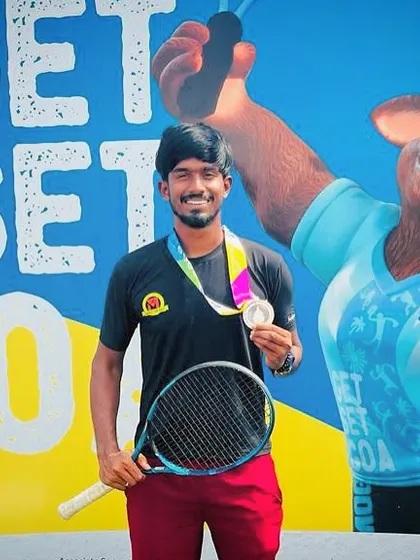 Oges proudly posing with his National Games silver medal and racket.