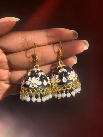 These black Meenakari hook earrings with hand-painted white lotus designs and pearl drops are a sold-out design. Their classic colour combination is always in demand.