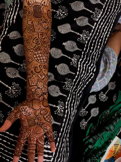 A single arm view of bride Noora's intricate henna. You can see the fine lines and detailed fills that go into creating such a complex and beautiful design.