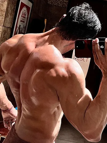 A powerful back and arm pose, a result of never settling for average.
