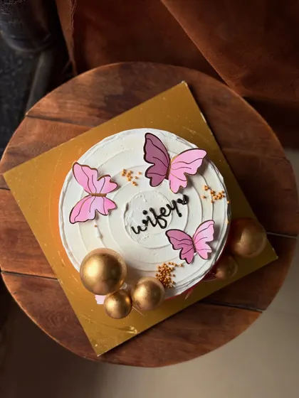 A beautiful cake for your "wifey," decorated with pink butterflies and golden spheres. It's a chic and modern way to show your love.