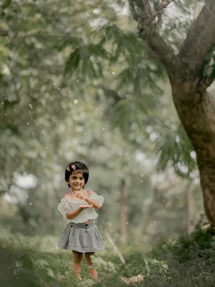 Blooming with laughter among the trees. This little girl's joyful expression is the highlight of this magical, woodland portrait.