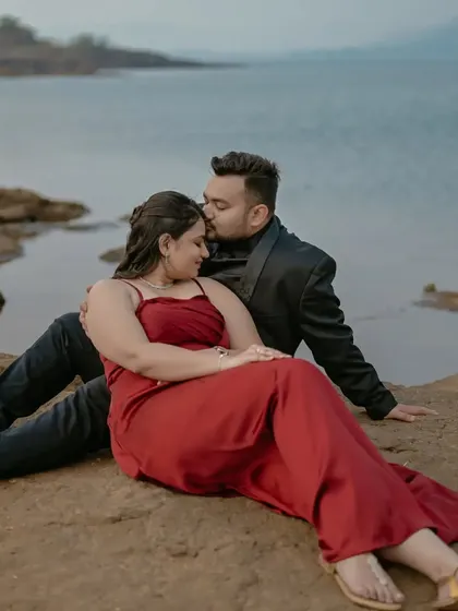 A gentle forehead kiss, a classic romantic gesture captured beautifully against the serene lakeside backdrop.