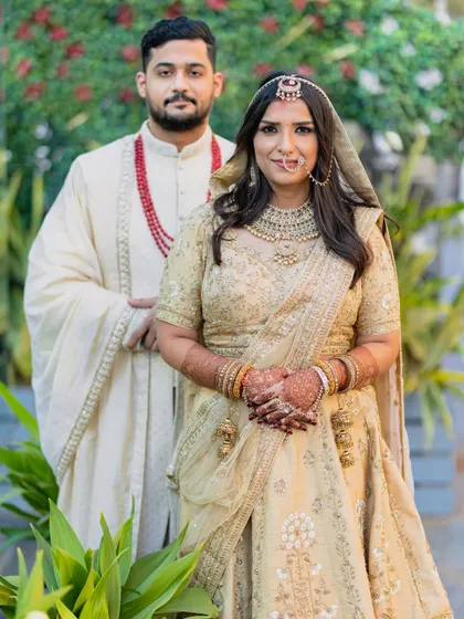 A formal portrait of the couple in their elegant gold wedding attire, looking regal and happy on their special day.
