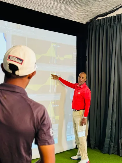 In our indoor studio, I use data to explain complex concepts to players. Here, I am pointing out specific metrics on the screen, connecting the feel of the swing to the real data, which accelerates learning and builds trust in the process.