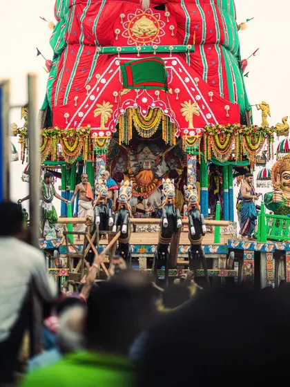 A close-up view of the magnificent chariot of Lord Jagannath, intricately decorated and surrounded by priests and devotees.