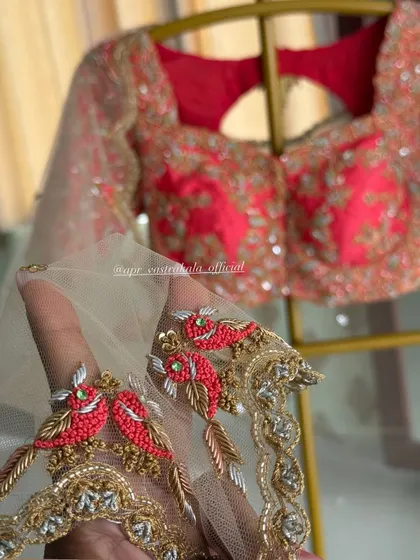 A red blouse with sheer sleeves, featuring bird motifs on the cuff.