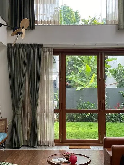 The living room opens directly onto the lawn, creating a perfect indoor-outdoor flow for family gatherings and relaxation.