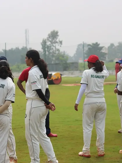 The women's team gathers on the field for a pre-match briefing.