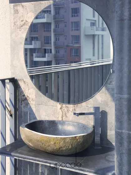 Even a small balcony space can be transformed into a functional and aesthetic corner. This powder room sink, crafted from raw stone, is set against a textured wall, creating a rustic yet modern feature that connects with the urban view.