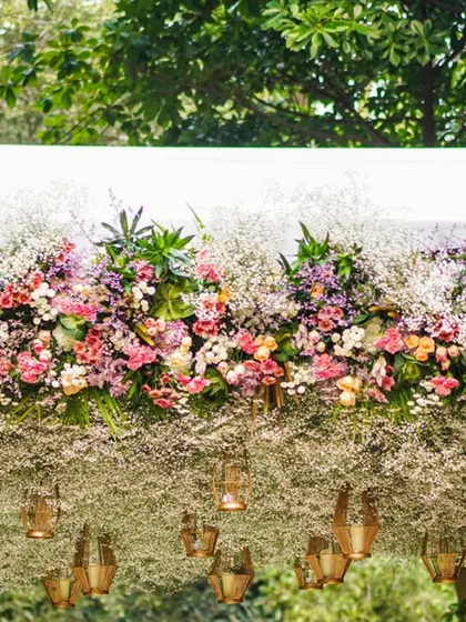 A beautiful pastel floral mandap designed for an intimate ceremony. The structure is covered in a cloud of baby's breath and adorned with pops of colorful pastel flowers, creating a dreamy, botanical look.