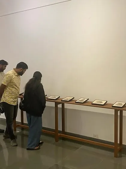A group of young visitors studying the intricate details of Shakuntala Kulkarni's work.
