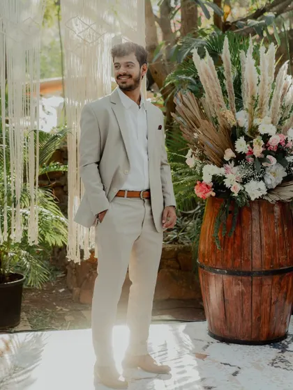 A candid shot of the groom-to-be, perfectly framed by our decor. The rustic barrel with a large floral arrangement and the macrame backdrop create a stylish and textured setting.