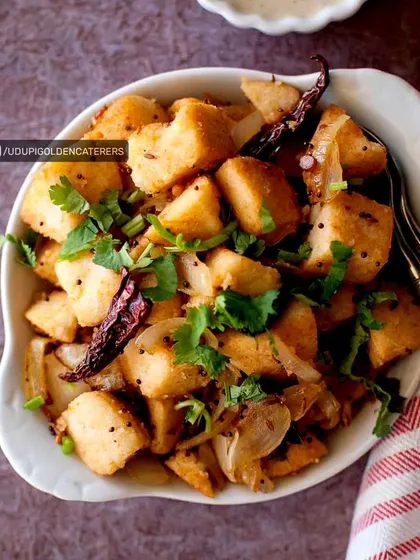 Our Fried Idli is a tasty appetizer where steamed idli cubes are tossed with onions, spices, and fresh cilantro. It's a creative and popular dish for any event.