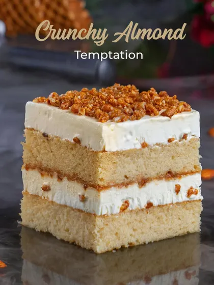 The Crunchy Almond Temptation ice cream cake, showcasing its layers and generous topping of crunchy nuts.