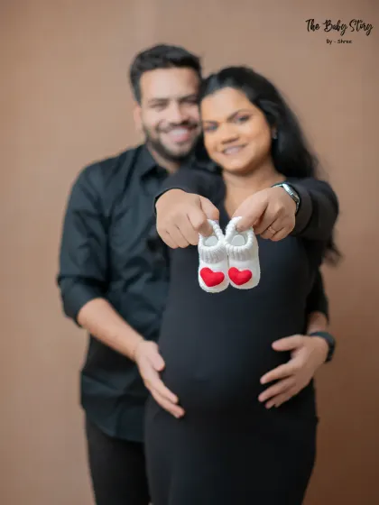 Another creative use of baby shoes as a prop. The couple holds them up to the camera, with their happy faces blurred in the background, putting the focus on the tiny detail.