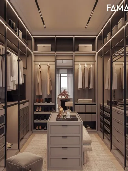 This walk-in closet is all about organization and style. It features an open-concept wardrobe system with designated spaces for clothes, shoes, and accessories, centered around a functional island with drawer storage.