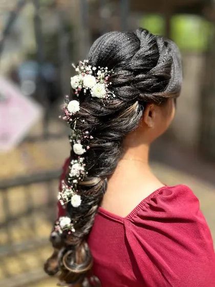 A messy mermaid hairstyle decorated with fresh baby's breath and small white flowers for a soft, bohemian look.