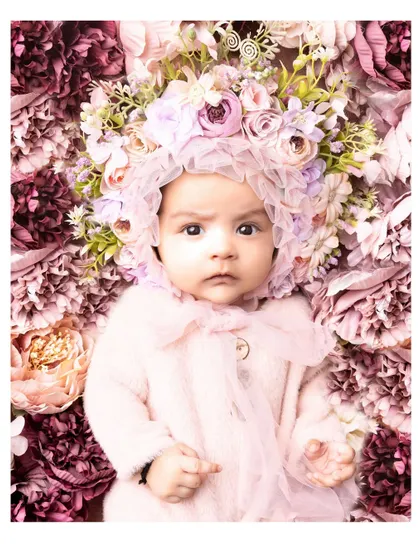 A 3-month-old baby surrounded by a bed of flowers. This artistic and beautiful setup creates a truly stunning and memorable portrait.