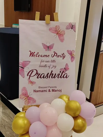 A personalized welcome sign for Prashvita's butterfly-themed welcome party. The simple easel display with a small balloon cluster is an elegant way to greet guests.