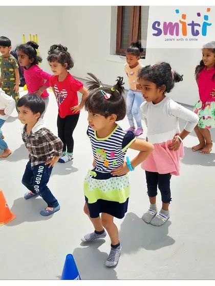 A group of children does squats, following their teacher's lead. Structured sports help develop motor skills and social skills.