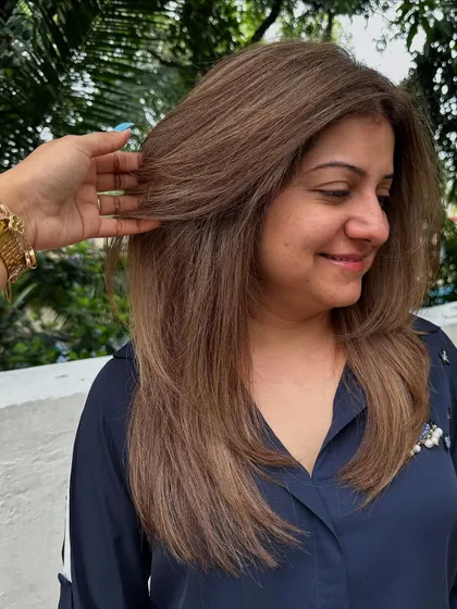 The happy client with her new cool-toned ash blonde hair and fresh, layered cut.