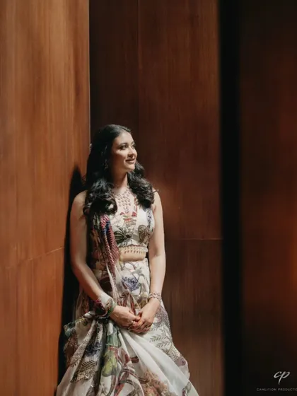 A portrait of the bride looking serene and happy before her welcome dinner. Her floral-printed outfit hints at the tropical, nature-inspired theme of the evening.
