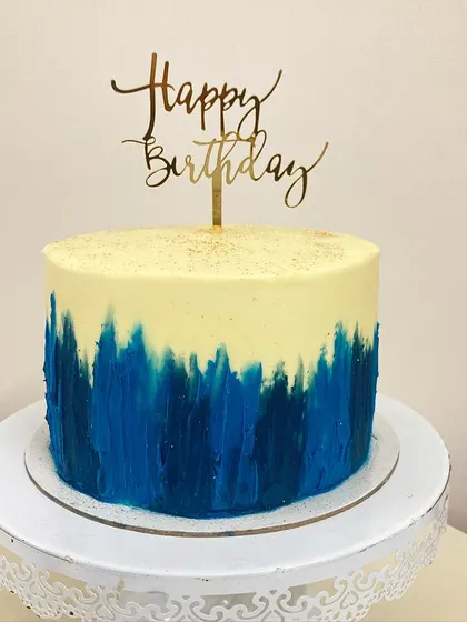 A simple yet striking design. This red velvet cake features a modern, hand-painted buttercream effect in shades of blue, creating a beautiful contrast with the cream cheese frosting.