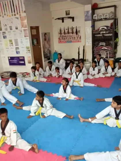 A group of yellow belts working on their splits. We build a strong foundation of flexibility from the very beginning.