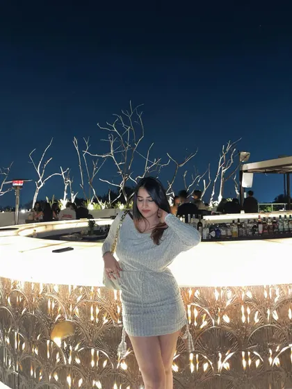A shot of the knit dress at the bar. This sets the scene and shows the outfit in a typical night-out environment.
