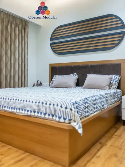 This master bedroom set includes a veneer-finish storage bed with an upholstered headboard and a matching bedside unit. The decorative wall panel above the bed adds a unique artistic element to the room.
