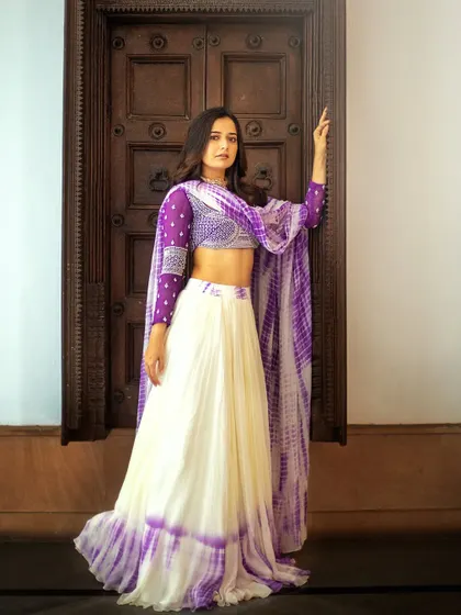 The full view of the tie-dye lehenga shows how the colors blend beautifully from the skirt to the dupatta. The embroidered blouse adds a touch of glamour to this bohemian-chic ensemble.