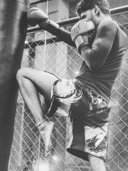 A student practicing a knee strike on the heavy bag. Kickboxing is not just about punches and kicks; we incorporate knees and elbows to provide a complete striking education.