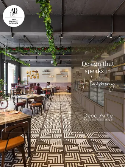 A design that speaks in harmony. This cafe interior features a timeless blend of textures, from the geometric floor tiles to the hanging greenery, all curated for an unforgettable experience.
