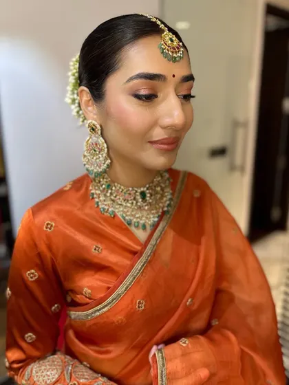 The makeup is clean and sophisticated, letting her natural beauty and the unique color of her outfit be the focus.