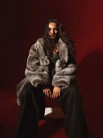 A high-fashion portrait with a luxurious faux fur coat. The dramatic lighting and the model's powerful presence create a glamorous and moody image.