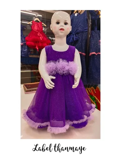 A simple purple party frock with tulle flower details at the waist.