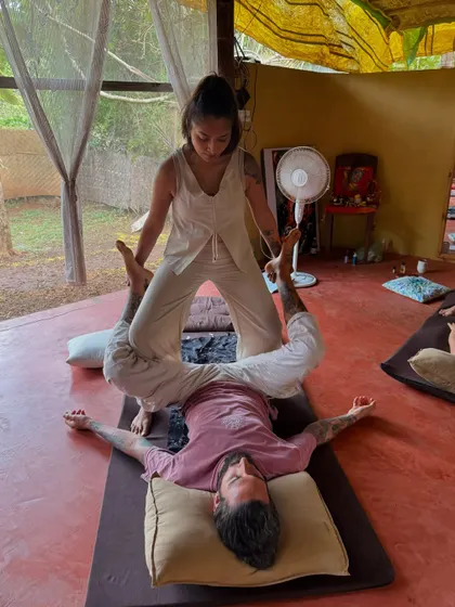 Applying pressure with my feet during a Thai massage training. This allows for a deeper, more sustained pressure that can release very tight muscles in the legs and hips.