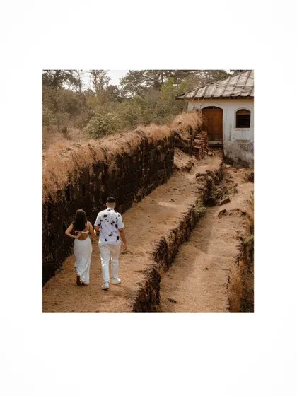 A walking shot capturing the couple exploring a rustic path in Goa.