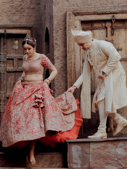 A classic moment where the groom helps his bride down the stairs, a gesture of care and partnership captured beautifully.